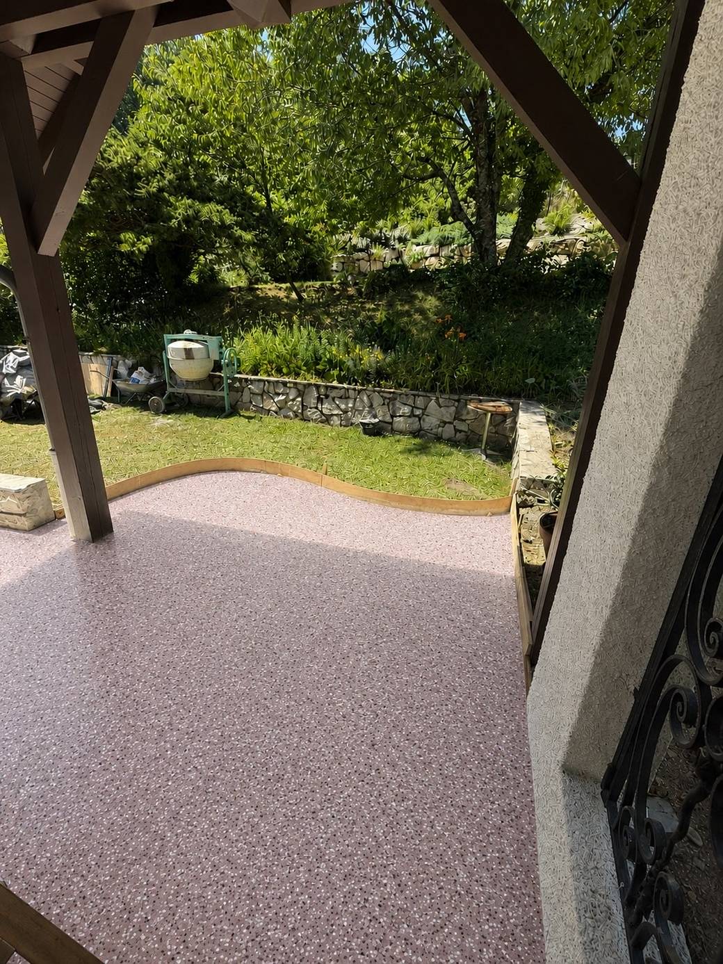 Terrasse extérieure sous tonnelle avec sol en résine effet flakes rose nacré, antidérapant — réalisation ALR Design